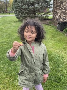 kid happy outside holding flower