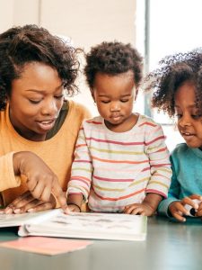 black mom reading spring books to kids aloud